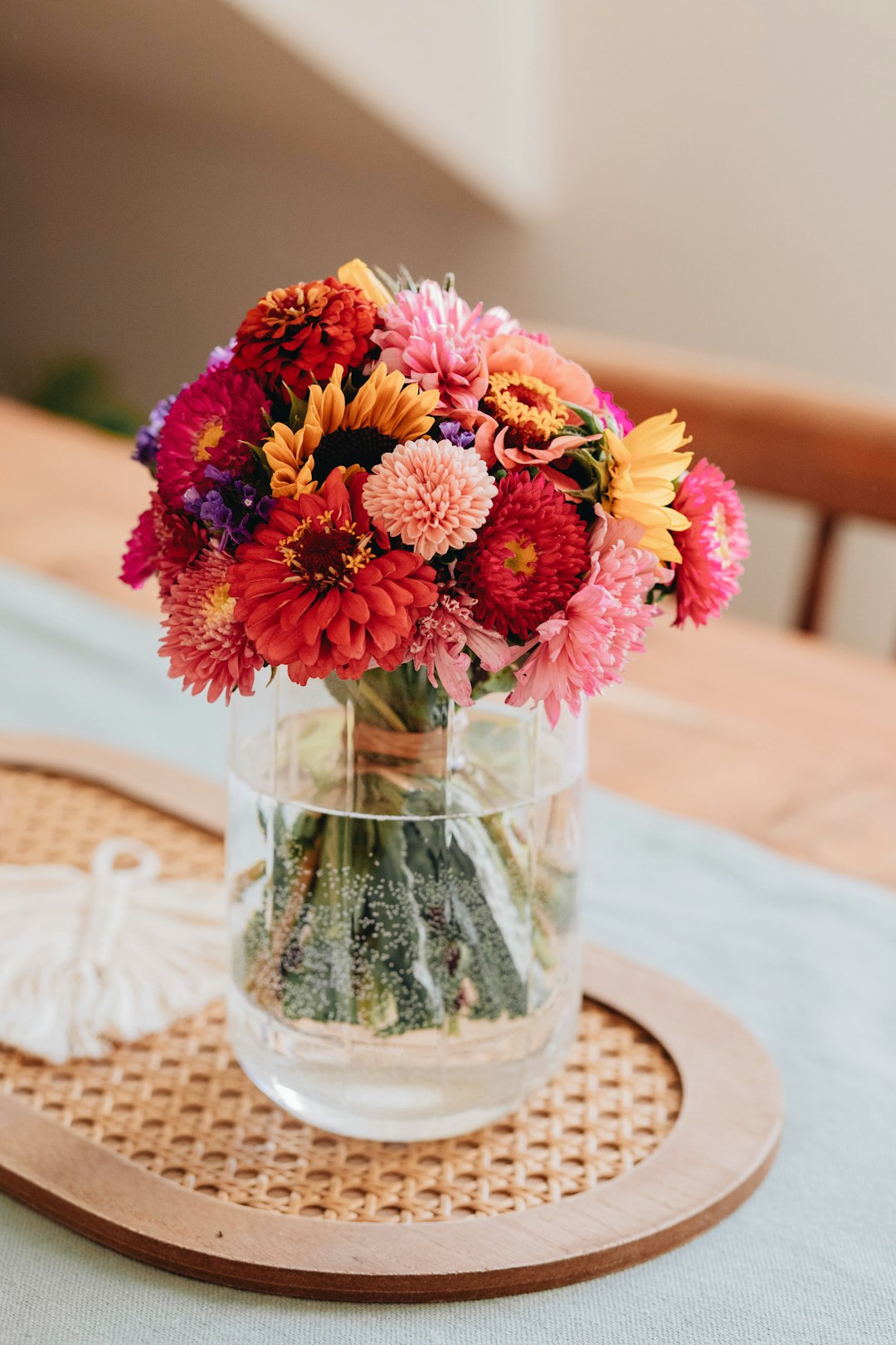 pink and yellow flowers in clear glass vase