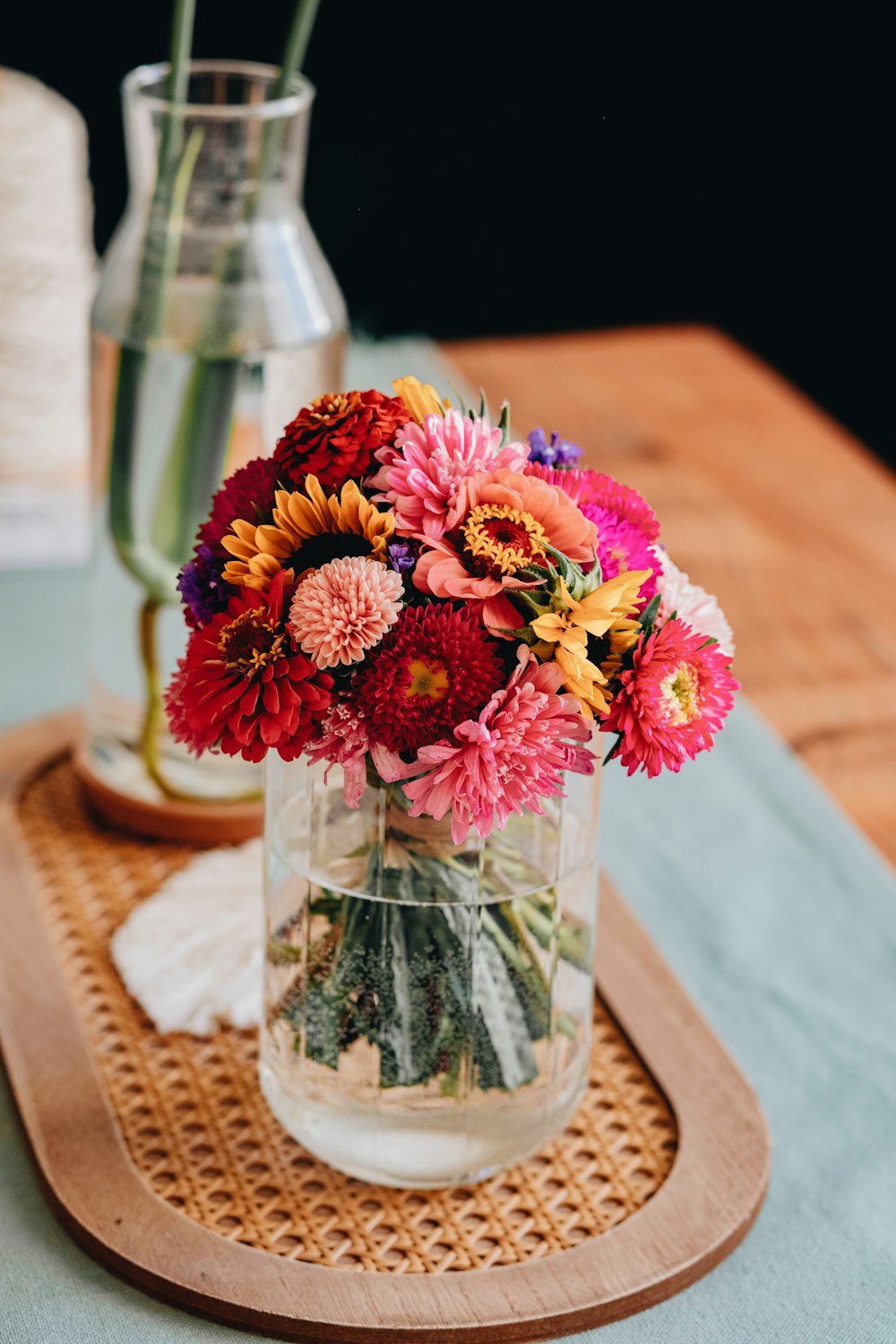 pink and yellow flowers in clear glass vase