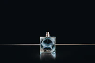 Skilled hands shaping molten glass into elegant perfume bottles at the workshop.