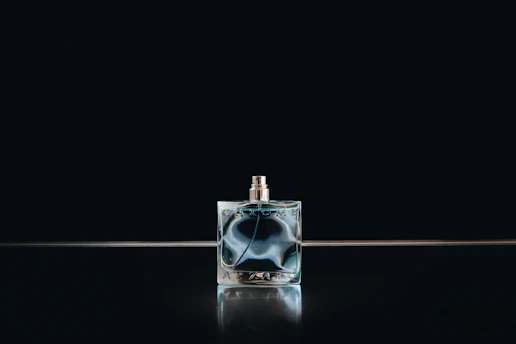 Close-up of a beautifully crafted custom glass perfume bottle with intricate details.