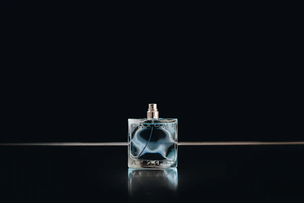 Close-up of an elegant glass perfume bottle with intricate design details reflecting light softly.