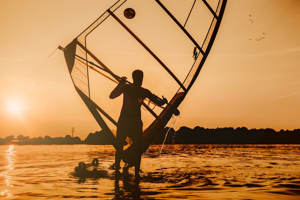 man in black shorts sitting on boat during sunset