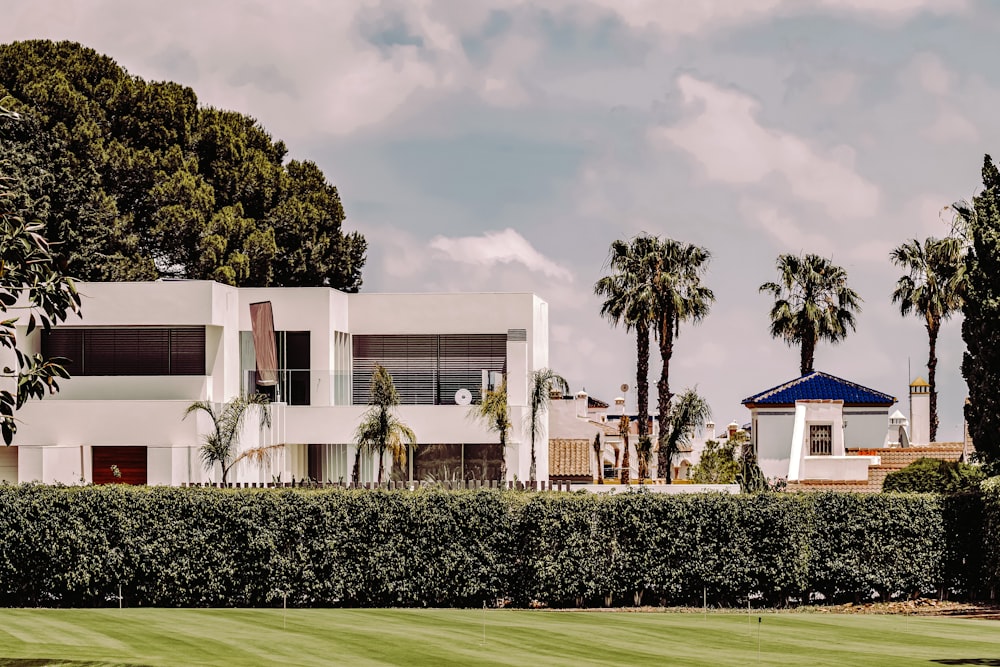 Edificio de hormigón blanco cerca de Green Grass Field durante el día