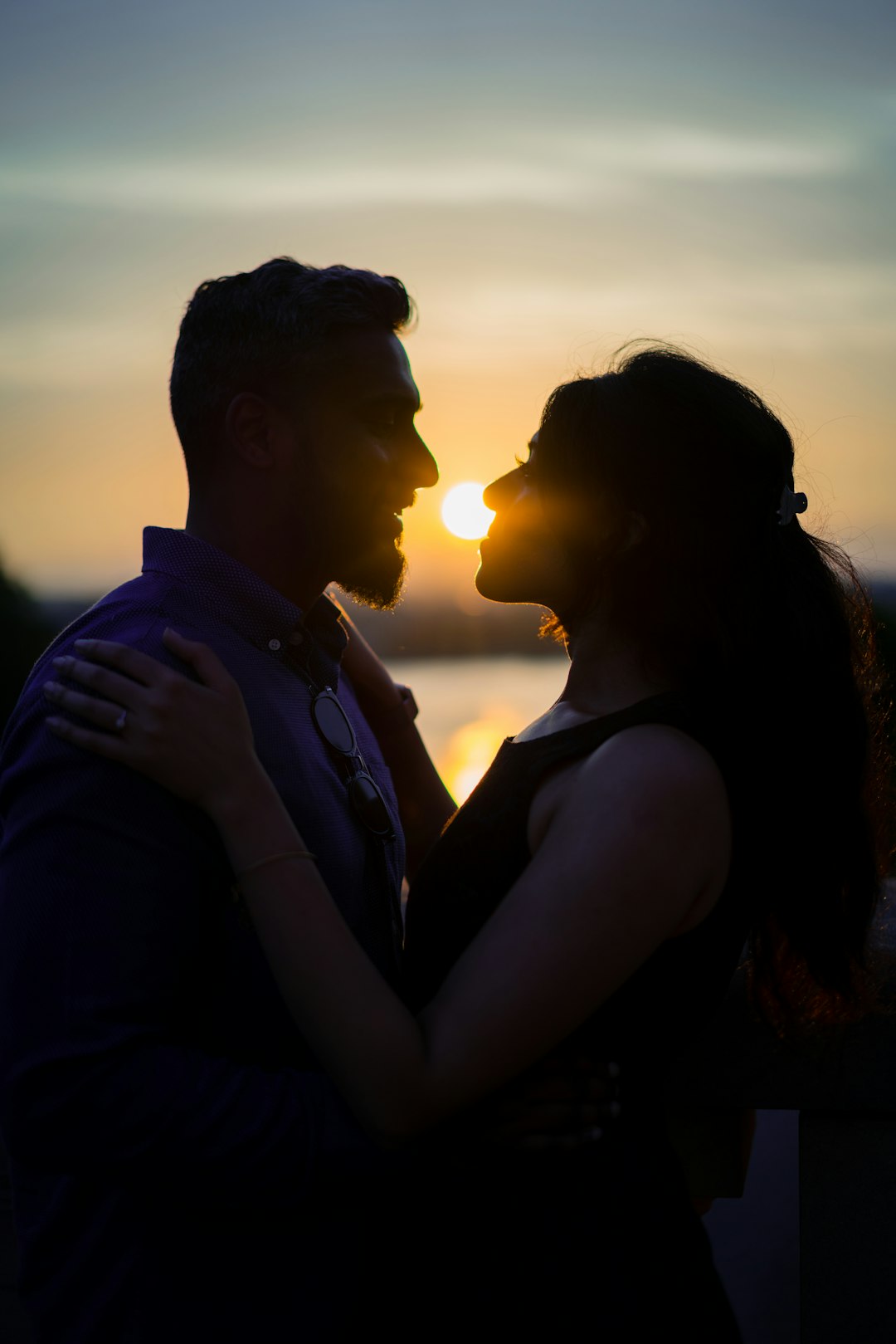 man and woman kissing during sunset