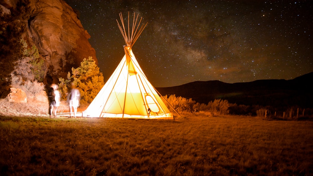 white tent on brown grass field during night time