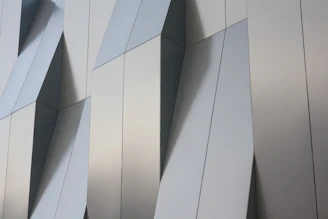 Architectural blueprint alongside custom-cut aluminum panels ready for installation.