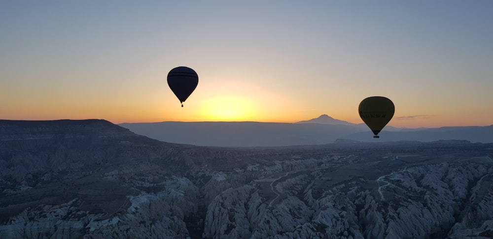 Mongolfiera che sorvola le montagne durante il tramonto