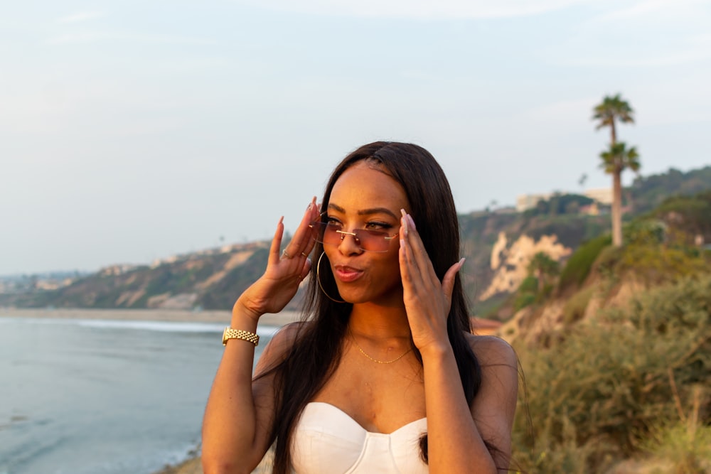 woman in white brassiere covering her face with her hand