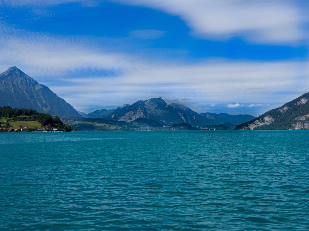 blue sea near mountain under blue sky during daytime