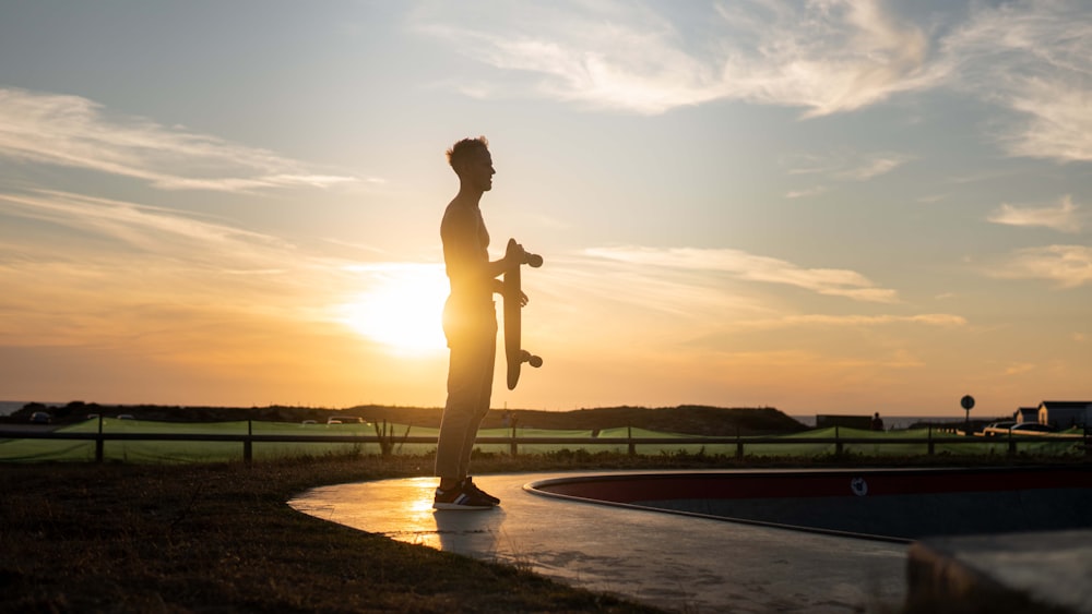 woman in black pants standing on brown concrete floor during sunset