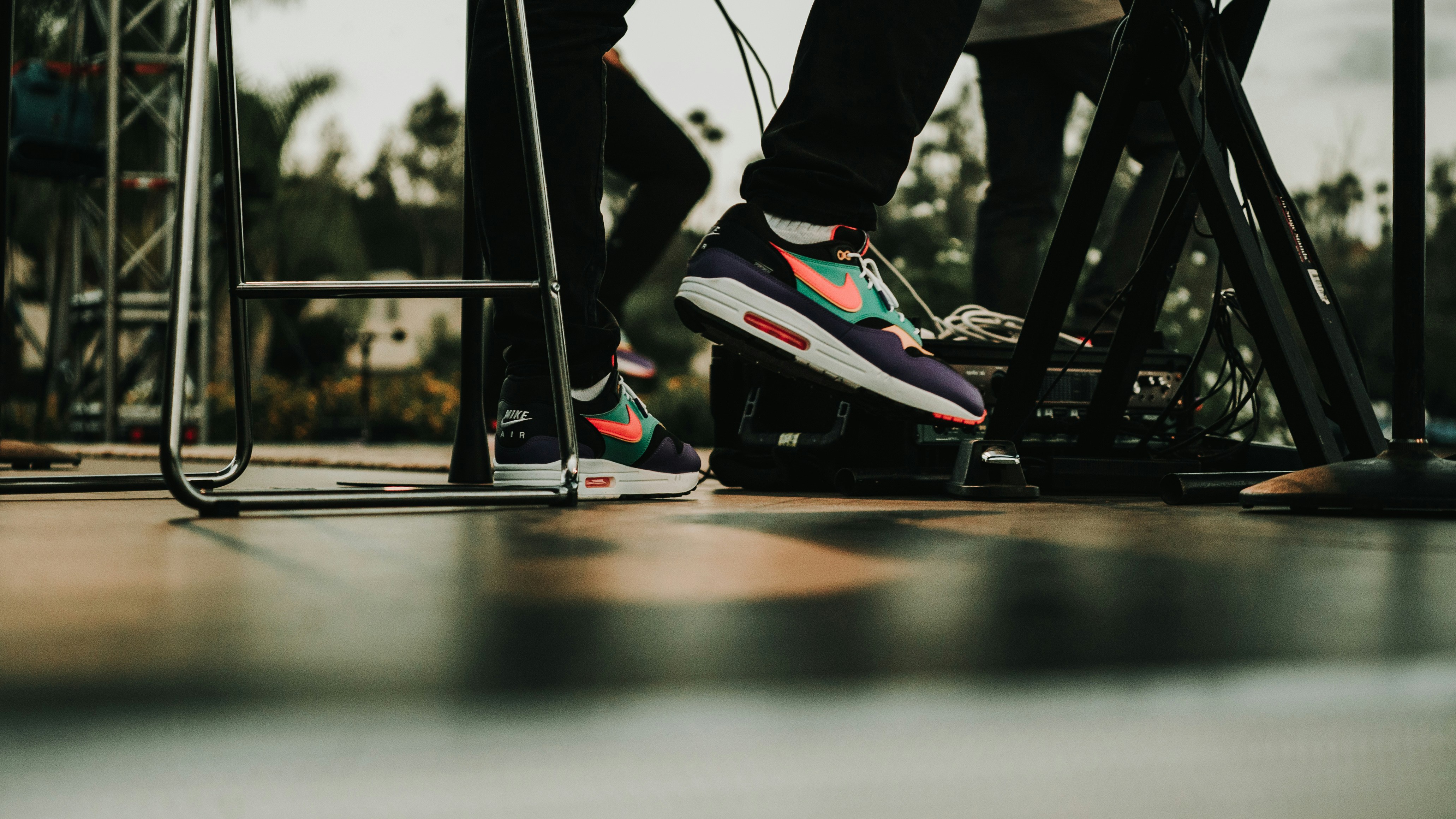 person in black pants and black and red nike sneakers riding on black and white skateboard