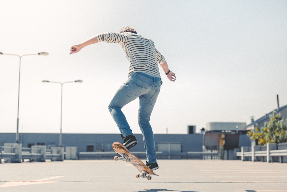 woman in black and white striped long sleeve shirt and blue denim jeans jumping