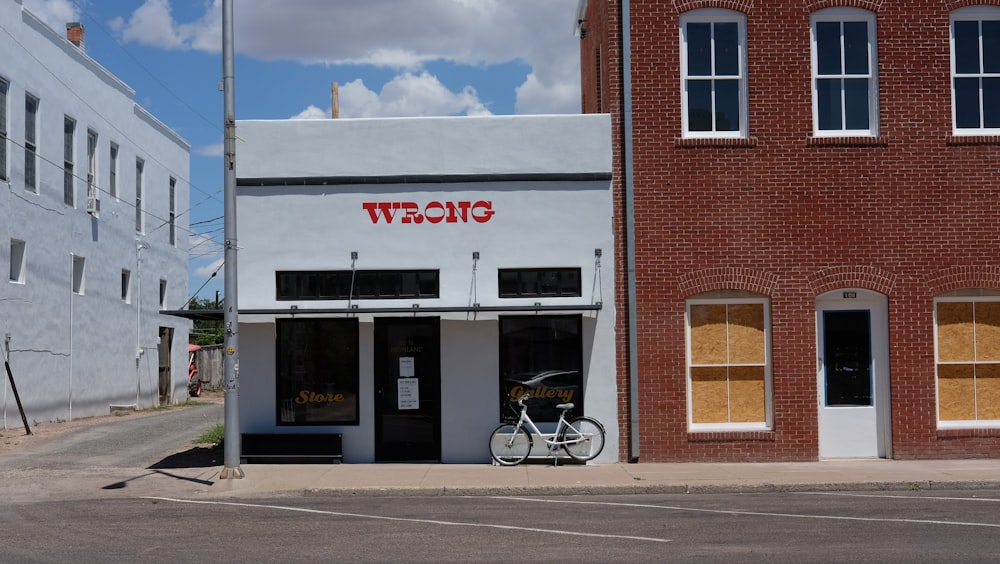 black bicycle parked beside brown brick building during daytime