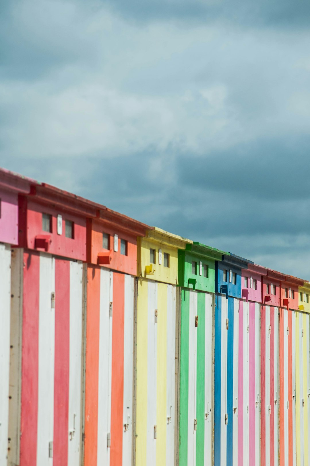 white red yellow and green wooden fence under white clouds