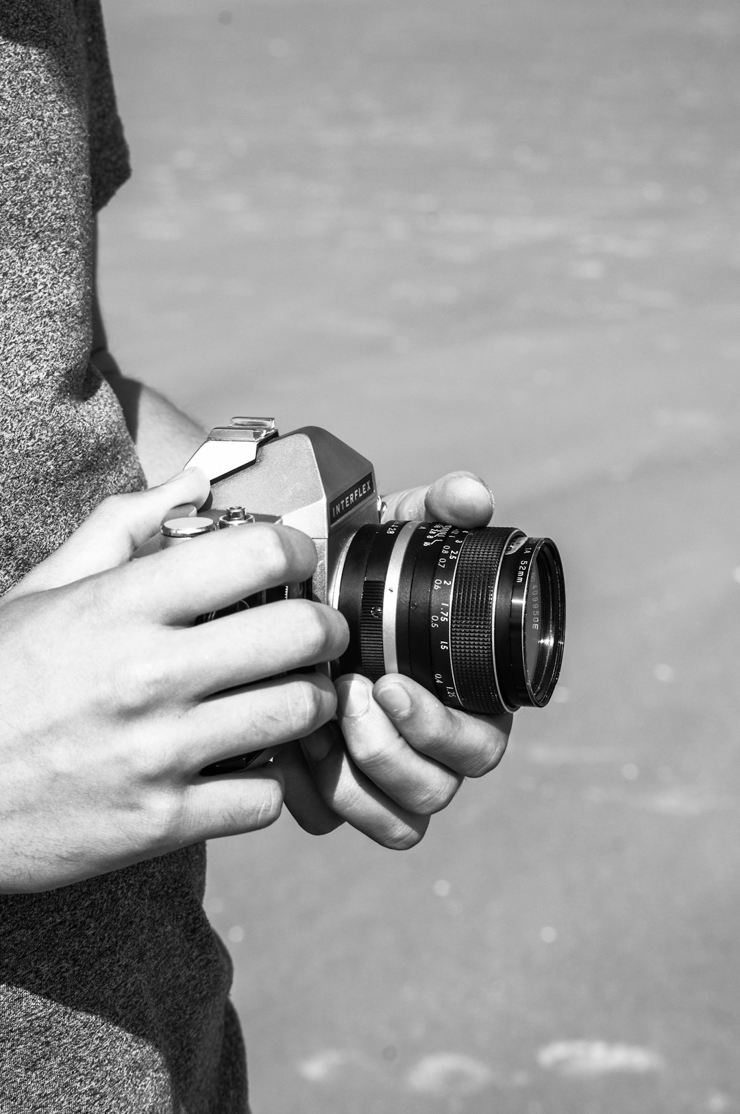 grayscale photo of person holding dslr camera