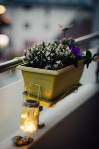 A colorful glazed planter with intricate patterns, showcasing blooming flowers on a cozy balcony.