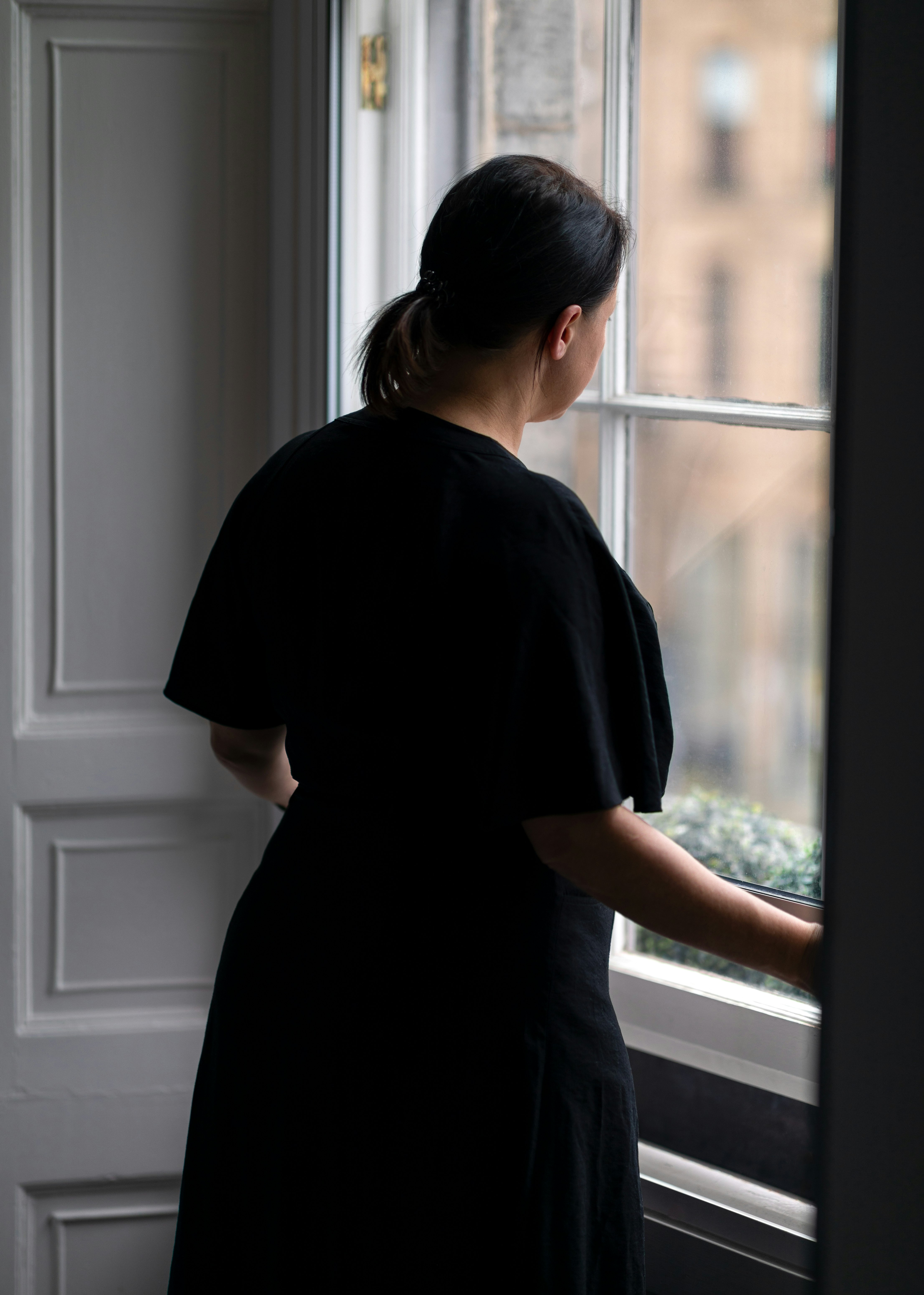 woman in black crew neck t-shirt standing near window
