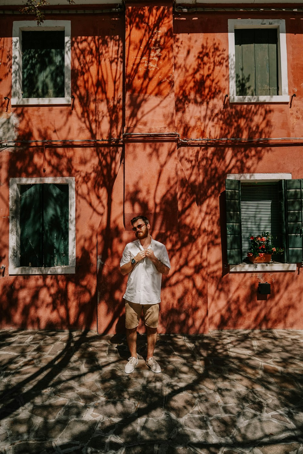 woman in white shirt and white skirt standing in front of window