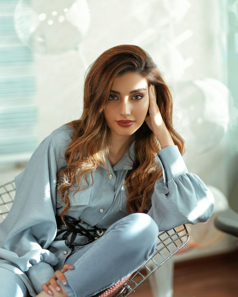 woman in blue denim jacket and white and black polka dot pants sitting on white chair