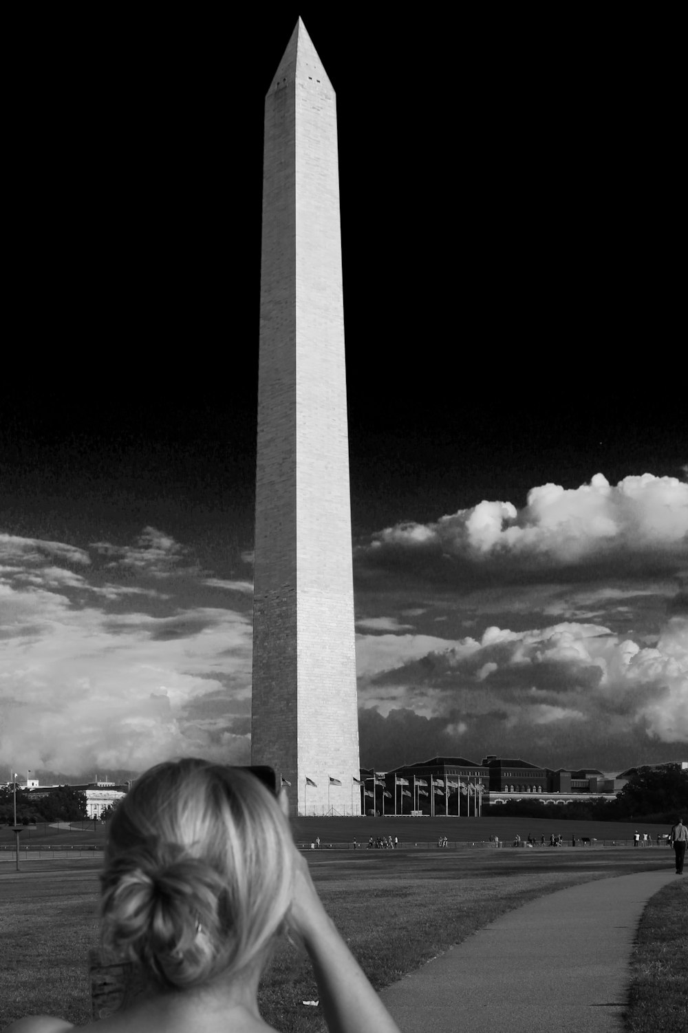 grayscale photo of woman looking at the building