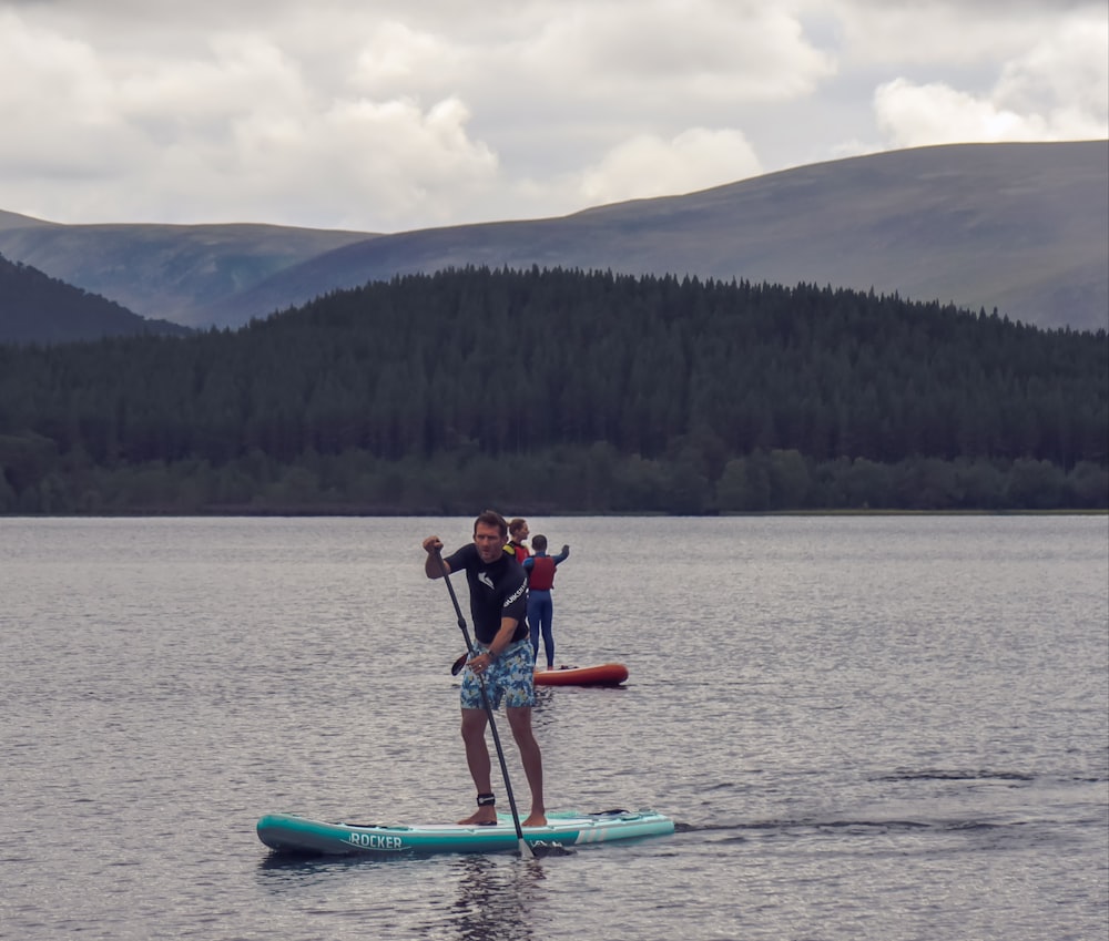 2 mujeres montando en kayak azul en el lago durante el día