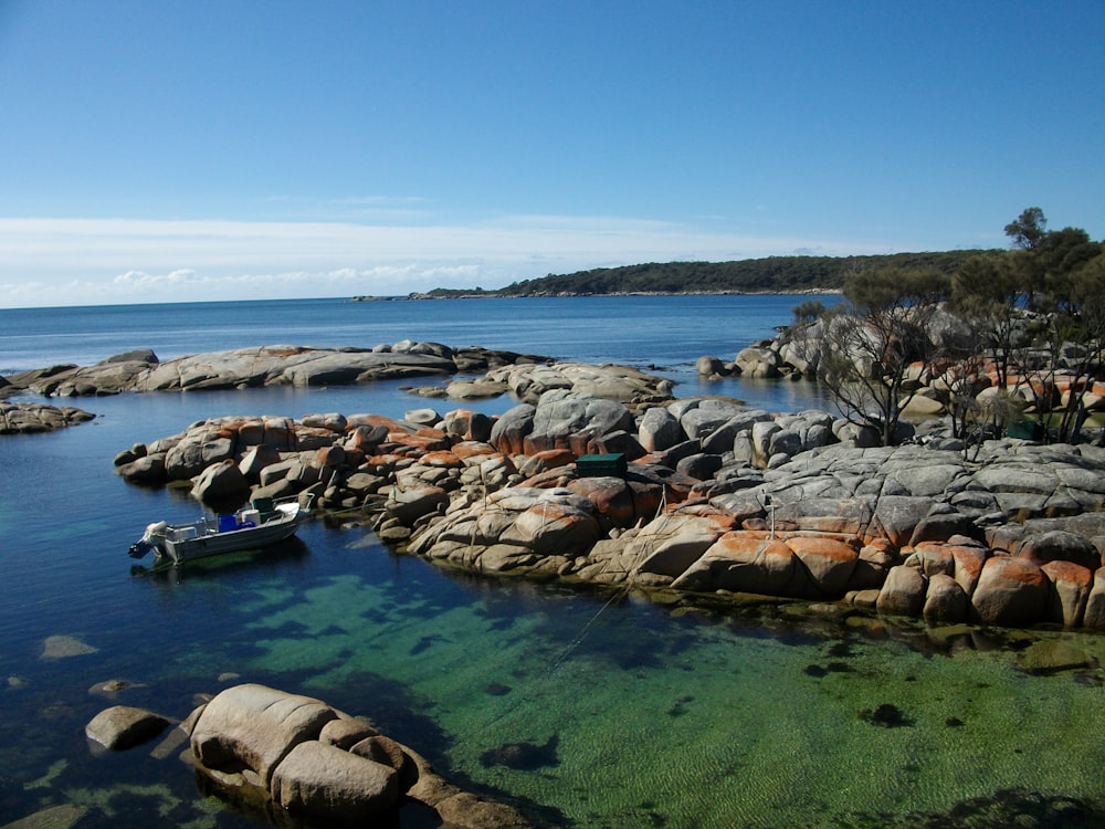 boats on sea near rocks during daytime