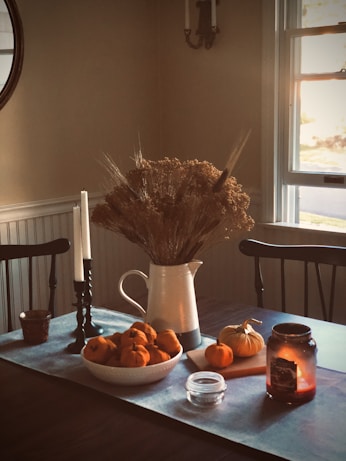 white ceramic vase with brown plant on brown wooden table