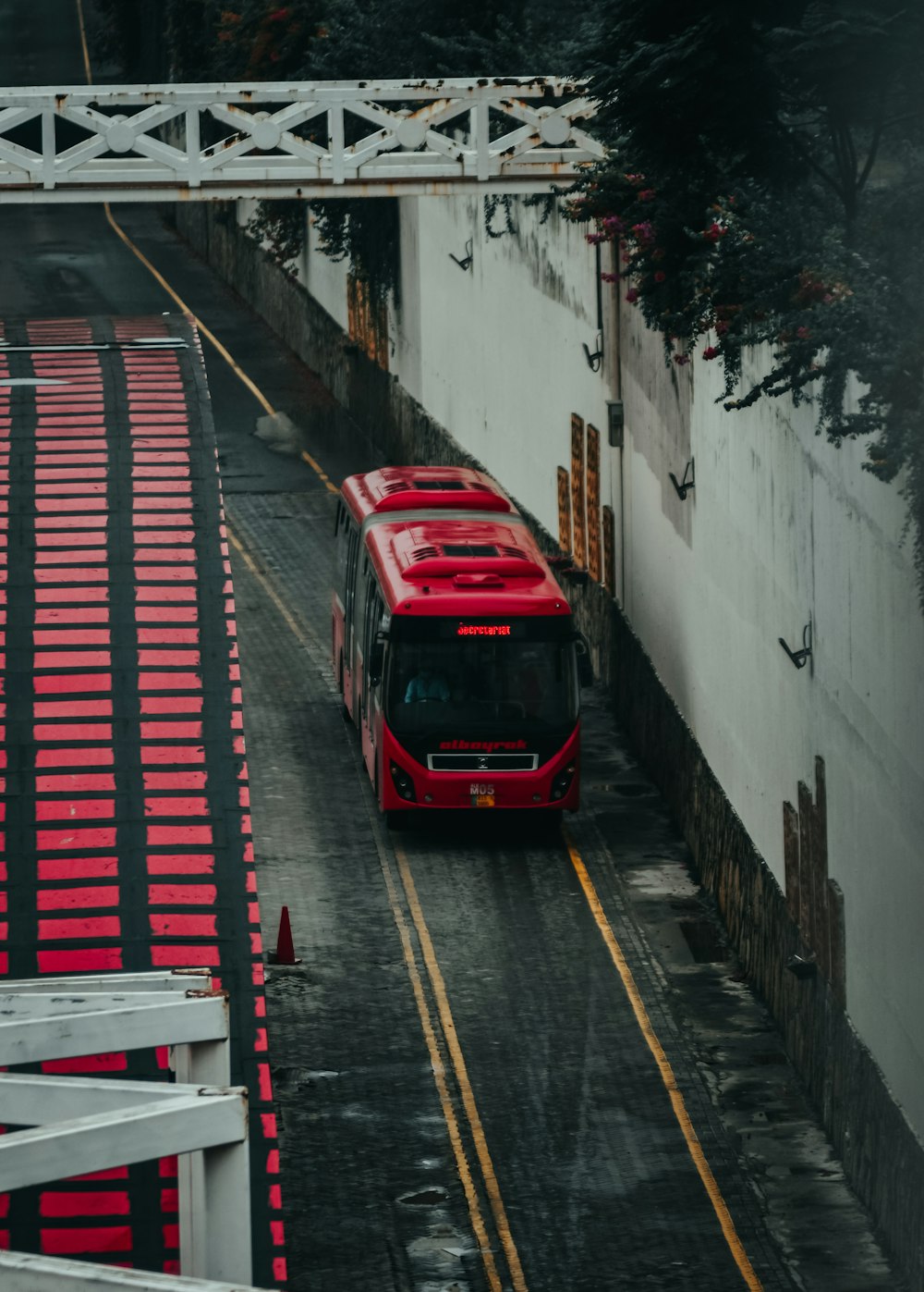 昼間の路上を走る赤と黒のバス