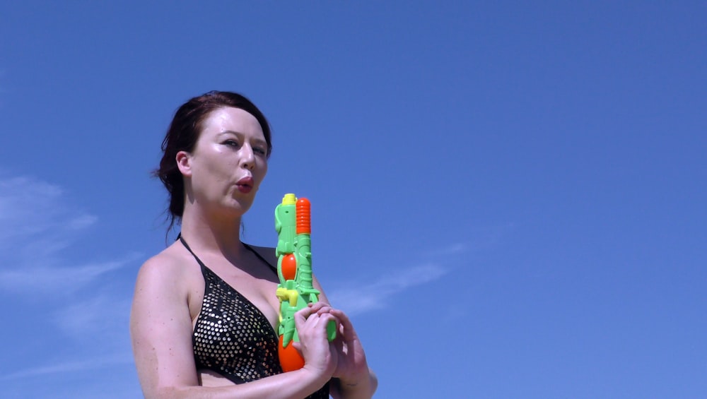 woman in black and white polka dot bikini top holding yellow plastic bottle