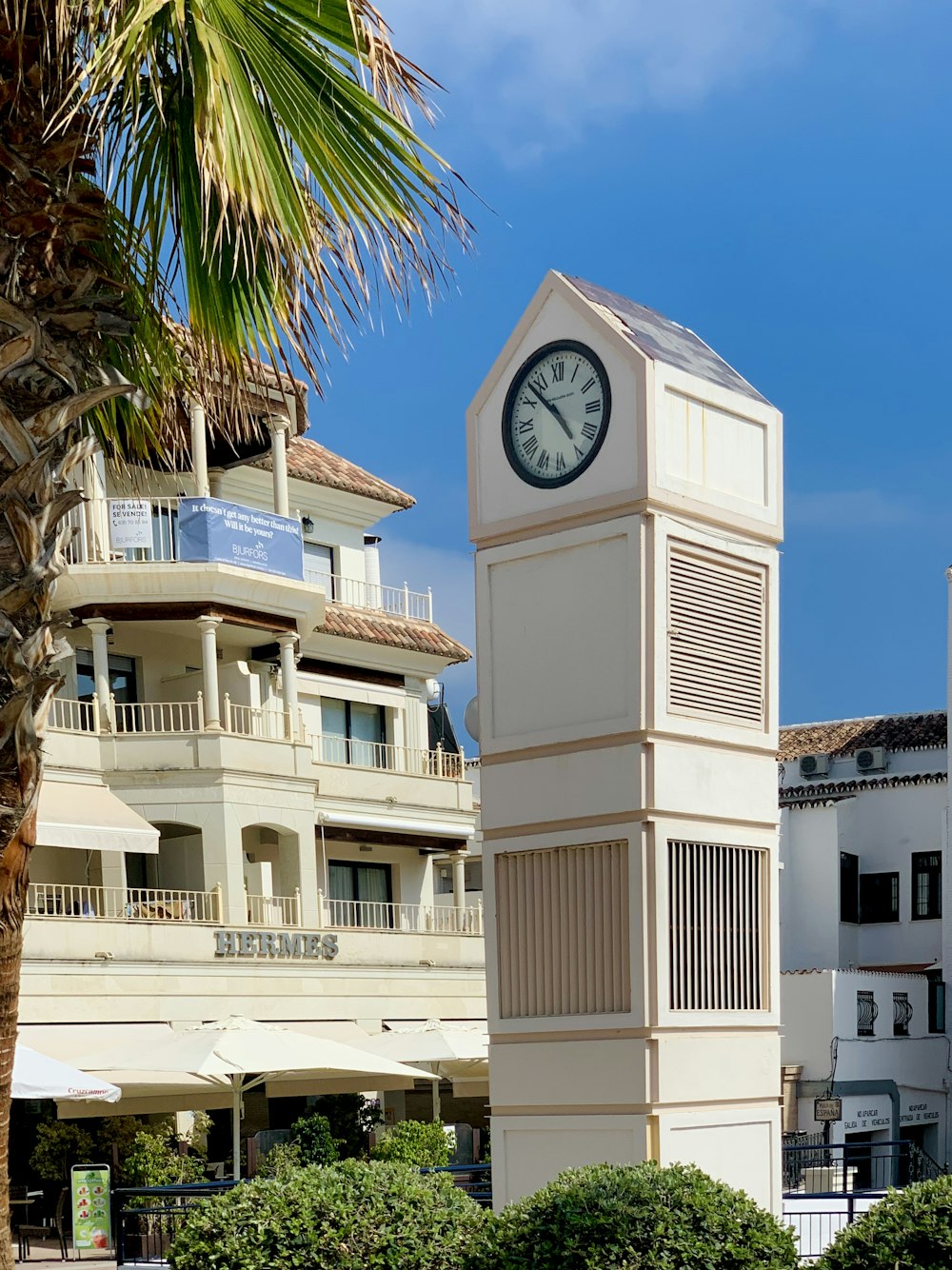 Edificio in cemento bianco e marrone con orologio a 1 40