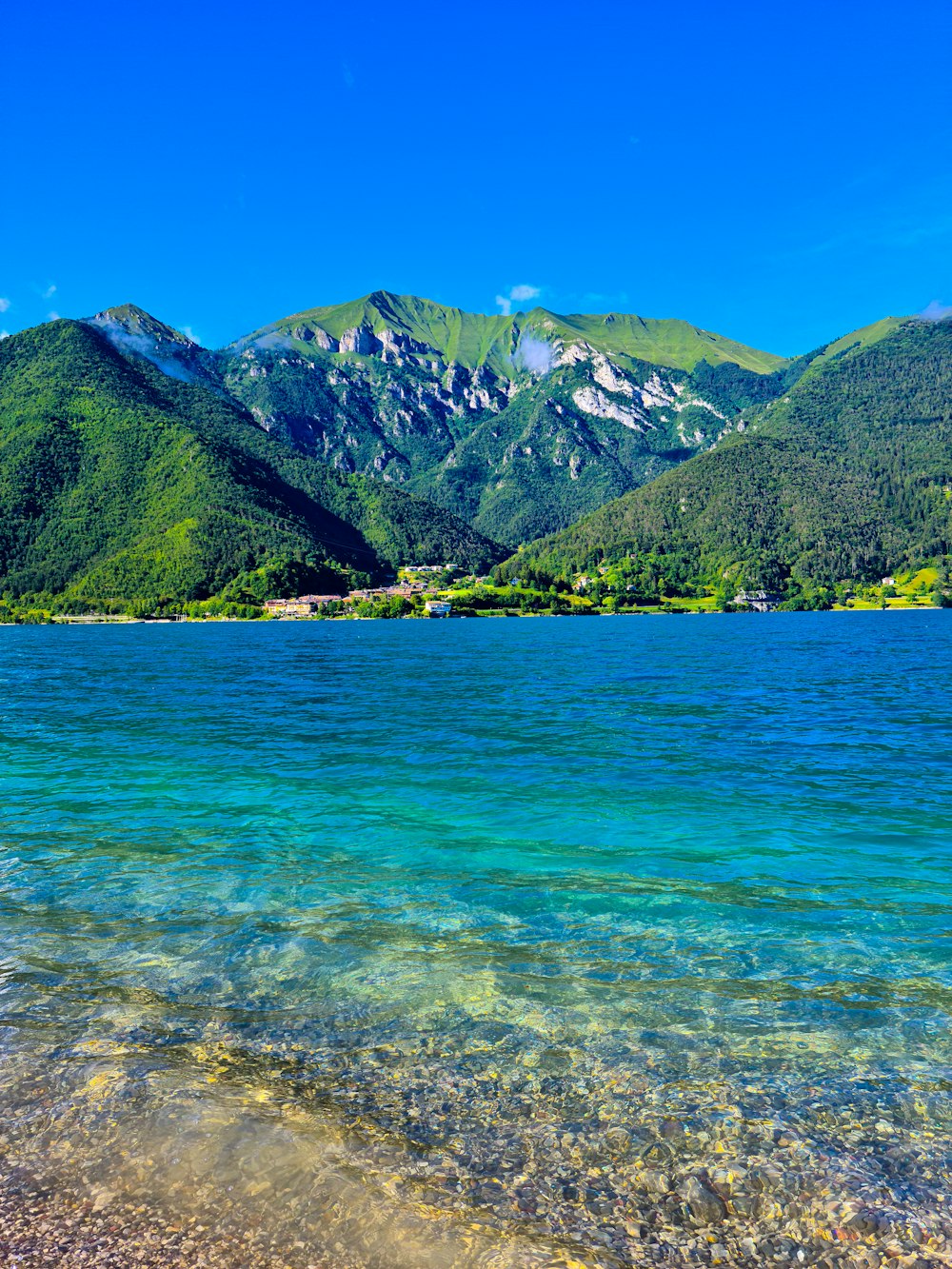 green and brown mountains beside blue sea during daytime