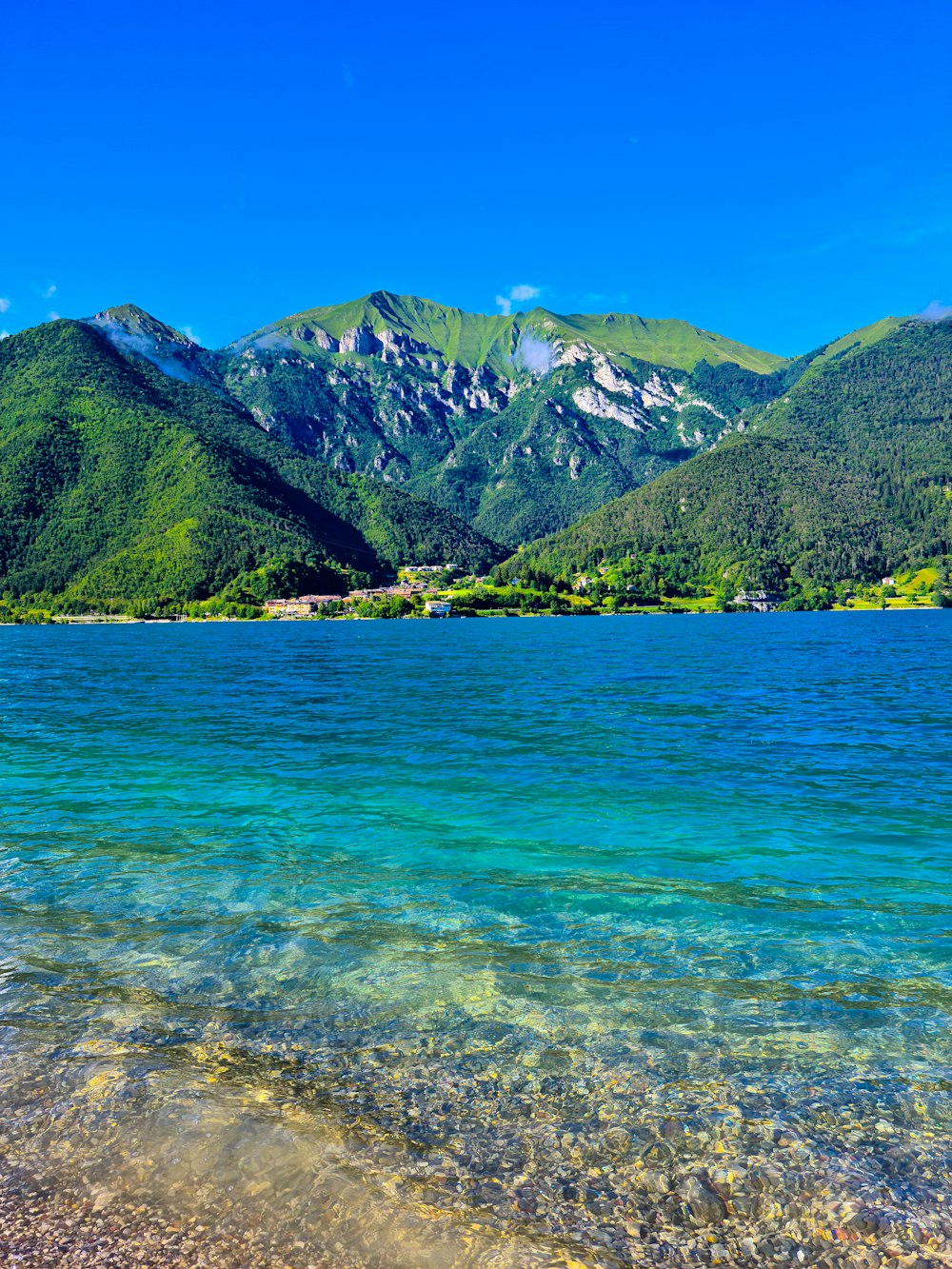 Montañas verdes y marrones junto al mar azul durante el día