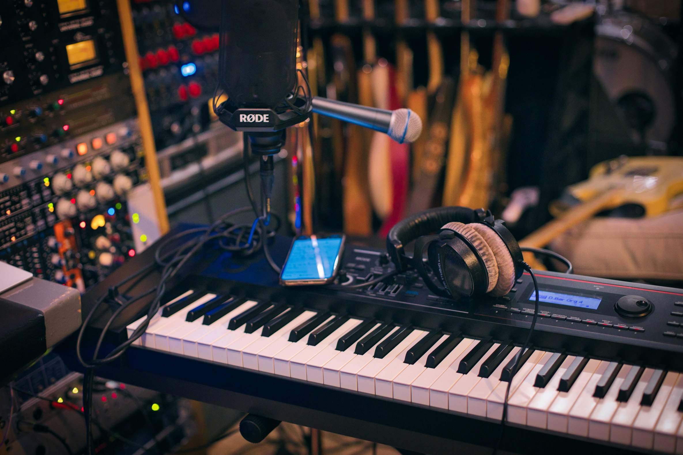 Keyboard vs. piano: Digital piano in studio with headphones and microphone on top.