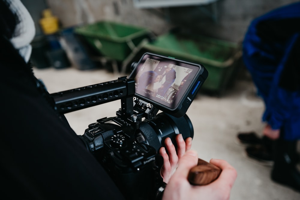 pessoa segurando câmera dslr preta