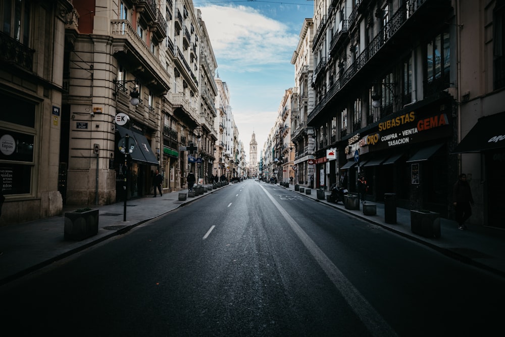 gray asphalt road between buildings during daytime