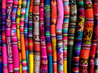 A beautifully arranged display of traditional Indian textiles in vibrant colors.