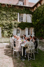 people sitting on white chairs near green trees during daytime