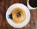 A happy person enjoying a bite of warm blueberry pancake at a cozy breakfast table.