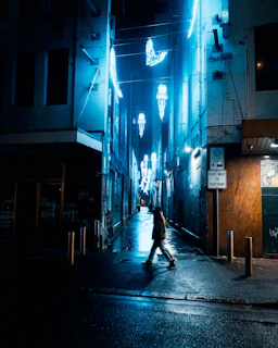 Dark mysterious alley illuminated by neon blue and green lights