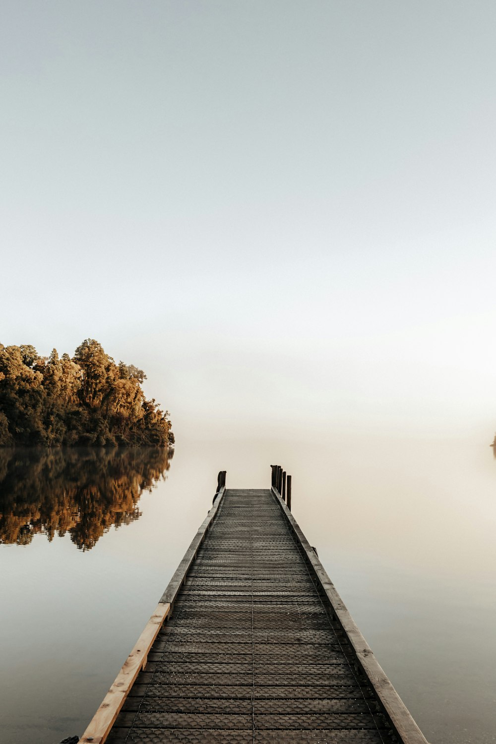 brown wooden dock on body of water during daytime