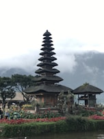 A tranquil temple surrounded by lush greenery and flowers.