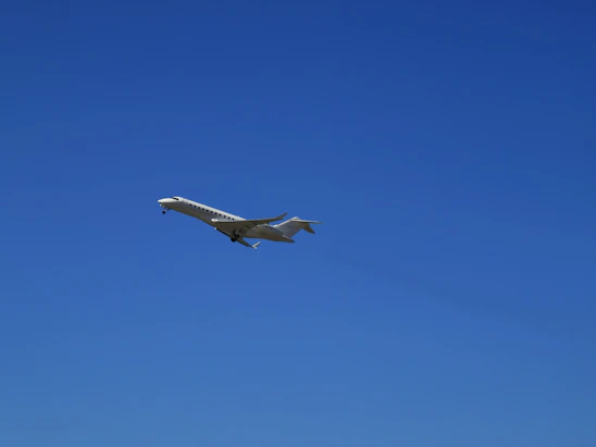A sleek private jet preparing for takeoff against a clear blue sky.