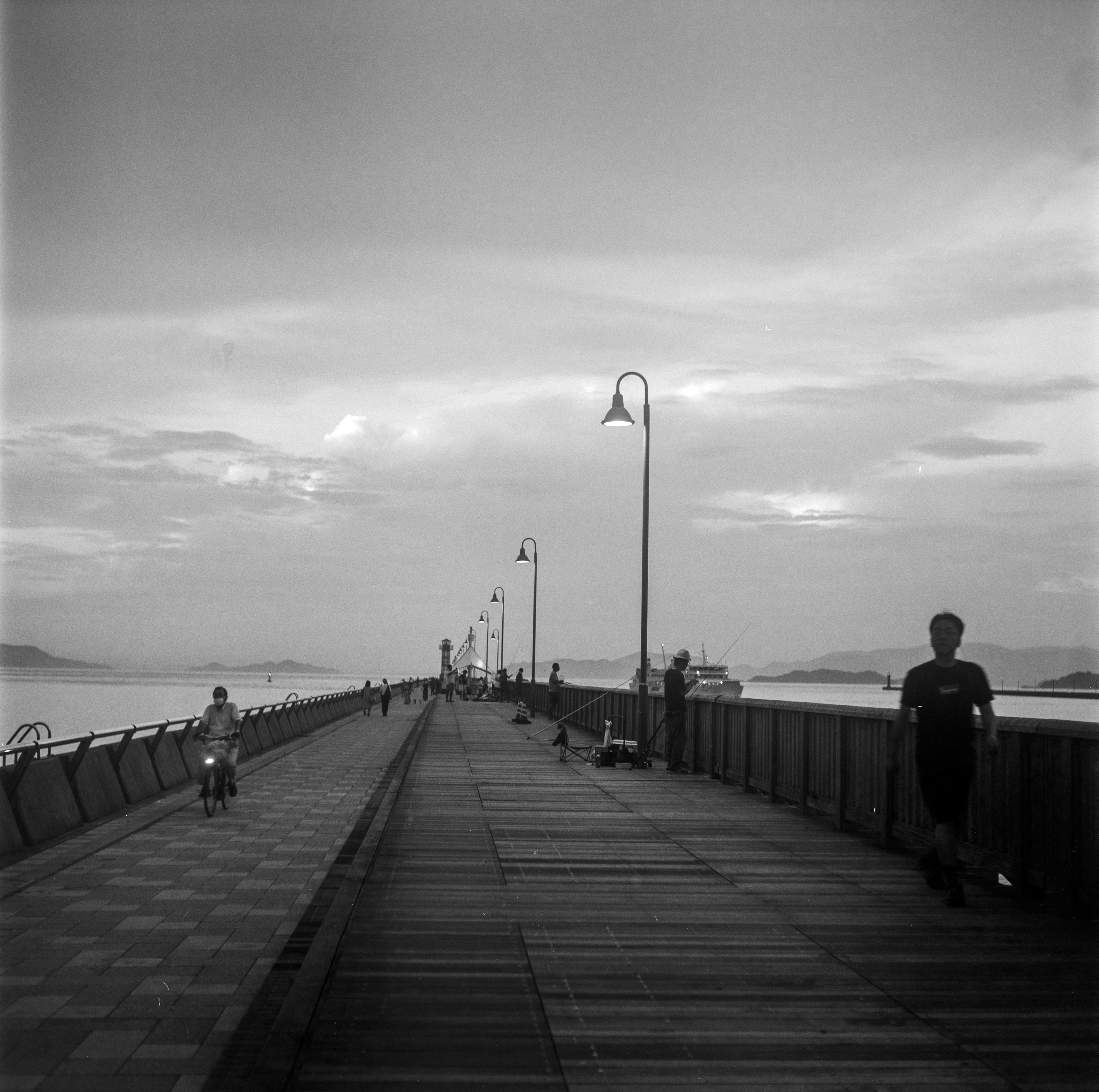 people walking on wooden dock under cloudy sky during daytime