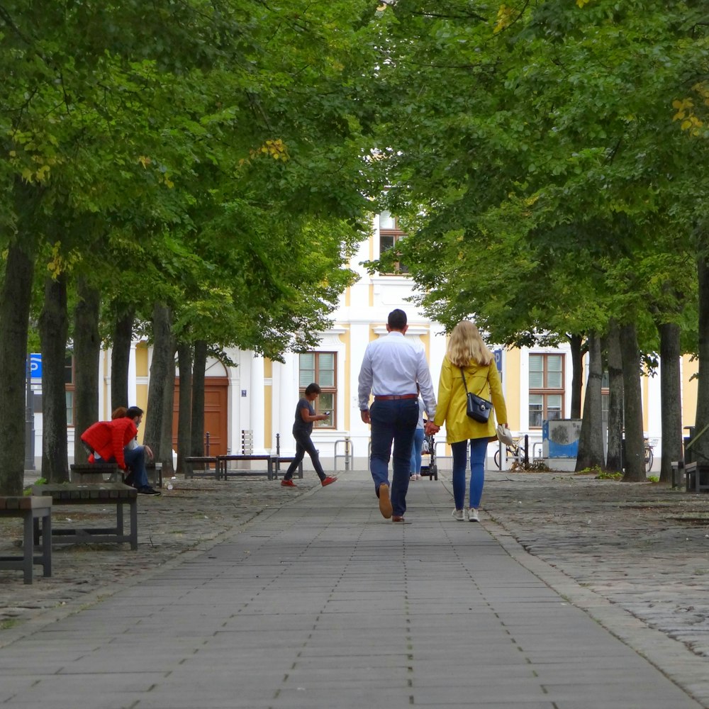 man in white shirt walking on sidewalk during daytime