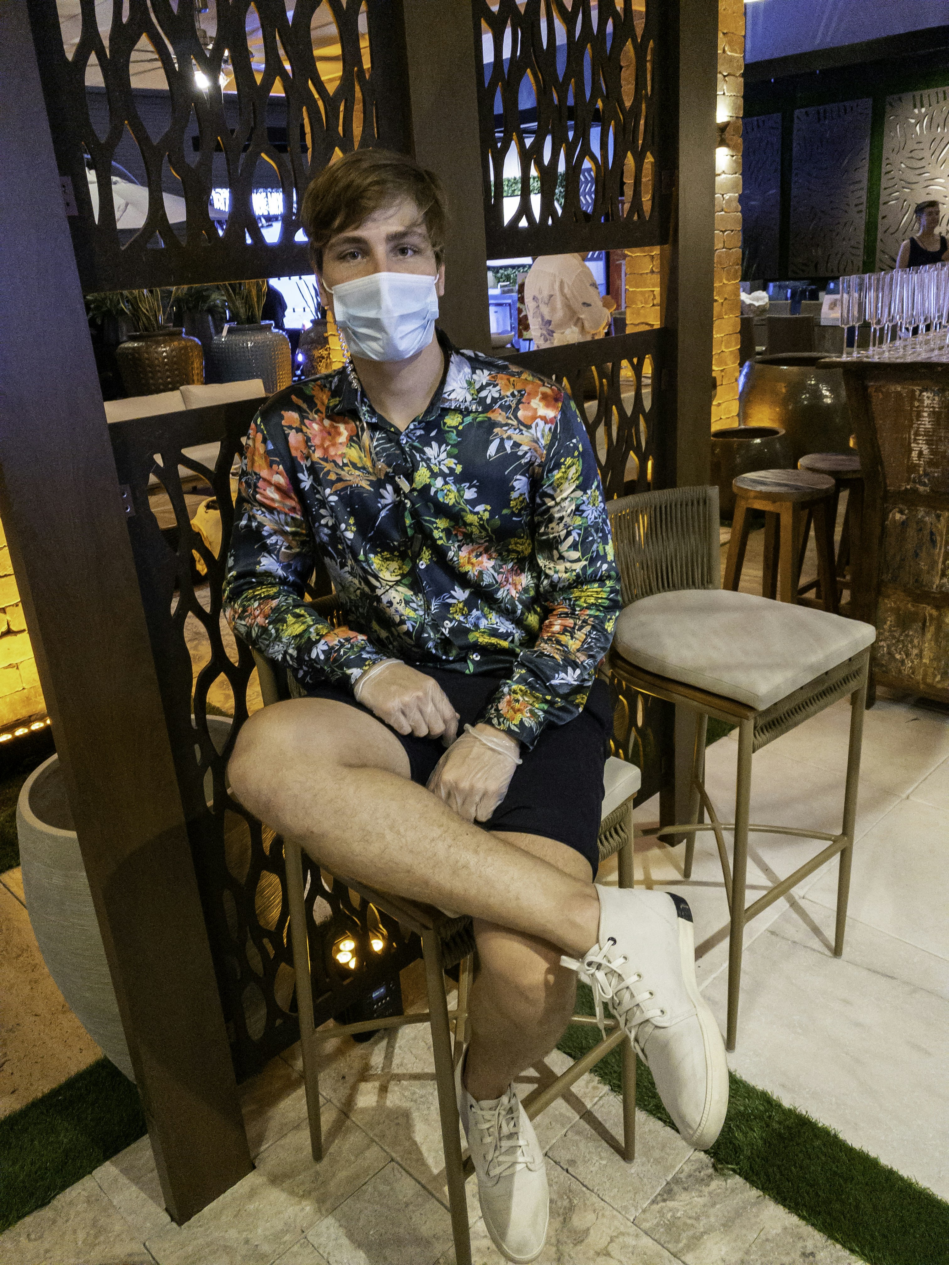 Young man with friendly smile in casual bar setting, warm amber lighting