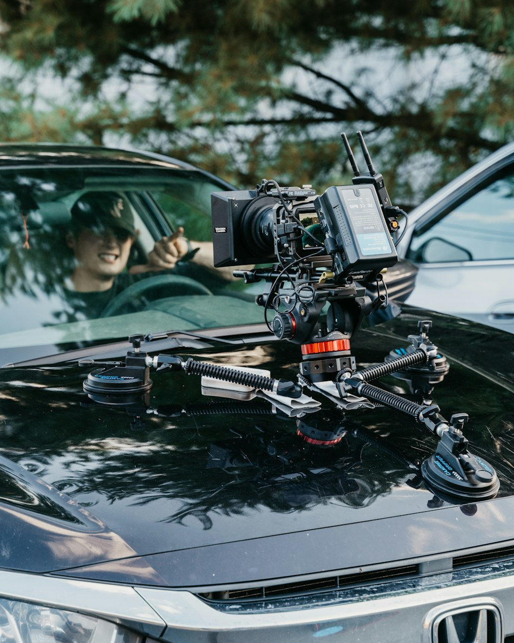 Cámara de video negra y plateada en el capó del automóvil negro