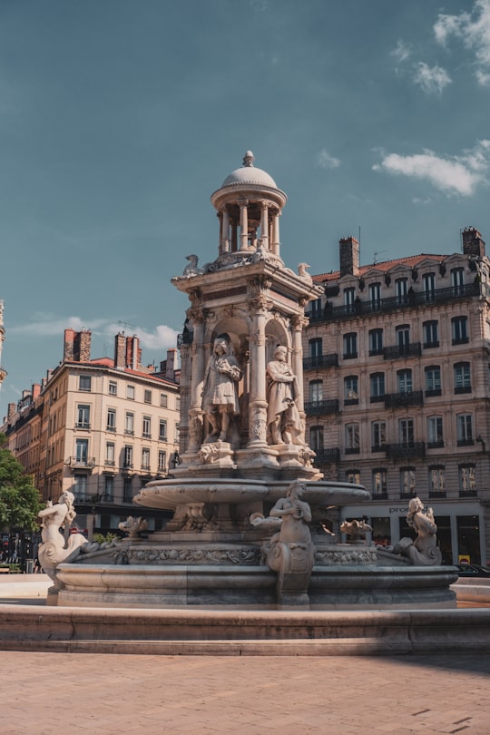 brown concrete fountain in front of brown concrete building during daytime in Place des Jacobins France