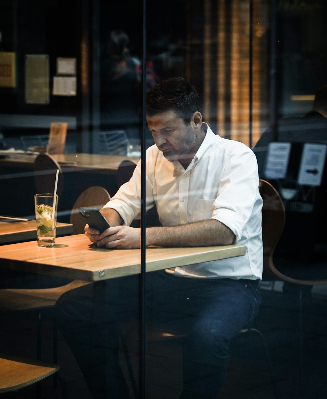 man in white dress shirt sitting at the table