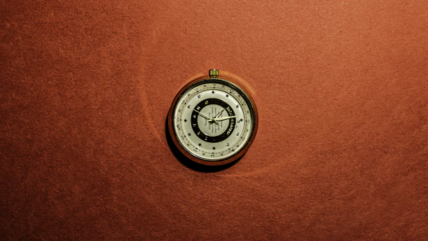Close-up of a vintage compass resting on an open intelligence report, symbolizing navigation through complex information.