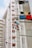 High-rise residential buildings featuring laundry hanging on poles extended from the windows. The walls of the buildings are painted in a mix of white and red. The image conveys a sense of urban living and community.